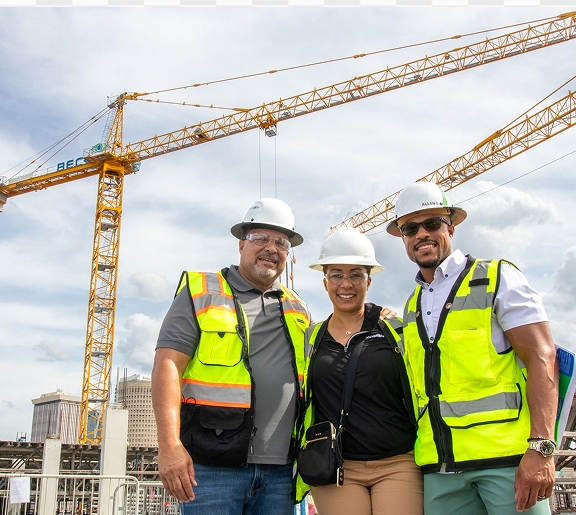Allen Green Senior Ariana Green and Allen Green Junior standing in from of a large crane wearing hard hats and safty vest
